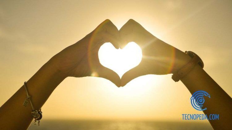 Manos haciendo un corazon en una puesta de sol