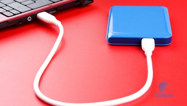 Disco Duro conectado a un ordenador sobre mesa roja