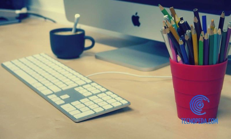 Teclado y lapicero frente a un ordenador
