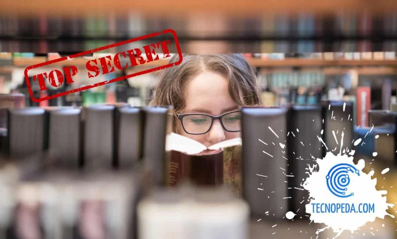 Mujer leyendo un libro detrás de una estanteria